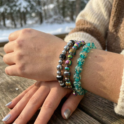 NOGU Made to Pair Chromata Mood Stone Bracelet stacked with iridescent metallic and turquoise beaded bracelets.