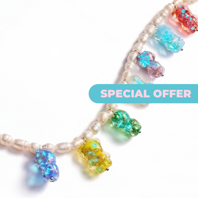 NOGU NECKLACES collection featuring a white pearl strand with colorful translucent gummy bear charms and special offer banner.
