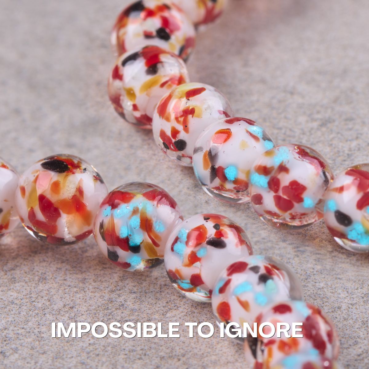NOGU bracelet with translucent glass beads featuring white centers and colorful red, turquoise, black, and yellow flecks.