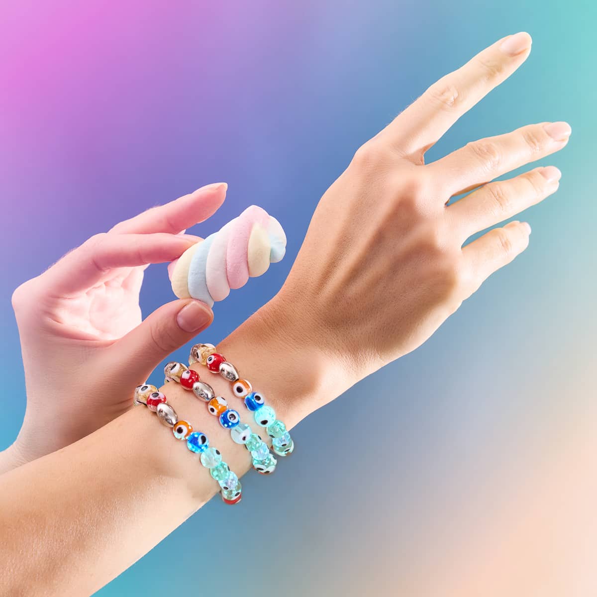 Wrist wearing three rainbow Firefly Glass Evil Eye Bracelets with multicolor beads and sterling silver details by NOGU