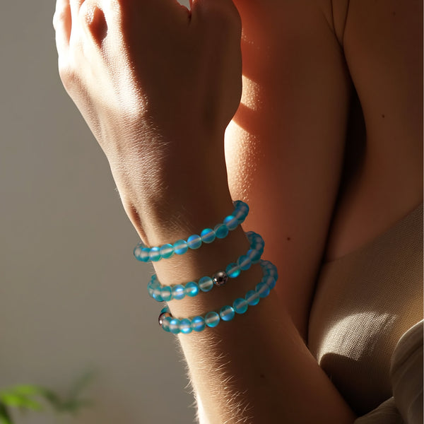 Aquamarine blue Mermaid Glass bead bracelets with silver stainless steel accents, layered on a wrist.
