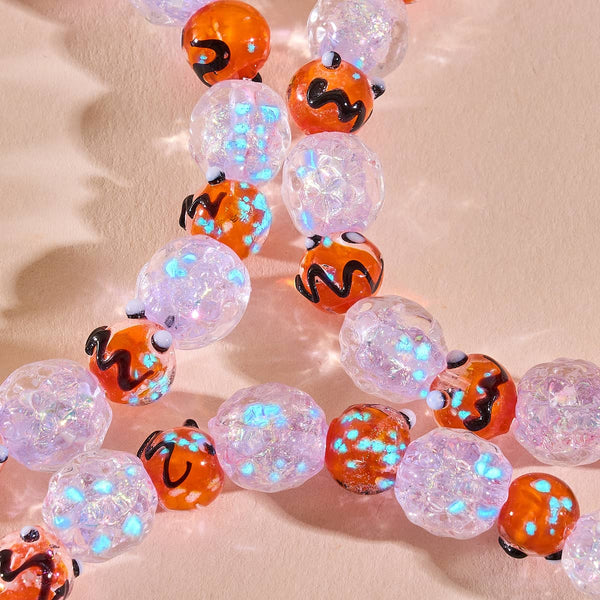 Moonlit Harvest Firework Glass Pumpkin Bracelet with orange pumpkin beads and iridescent clear glass beads that glow blue.