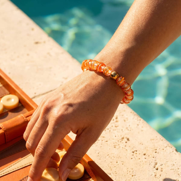 Honeycomb Firework Glass Sugar Bracelet with translucent orange glass beads and a polished gold-tone accent bead.