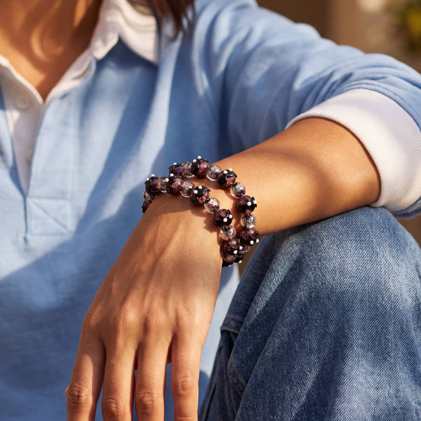 Violet Vesper Firefly Glass Bat Bracelet with black bat charms and shimmering purple glass beads on a wrist.