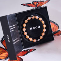 A stack of glowing bracelets on a woman's wrist, perfect for a chic Halloween look.