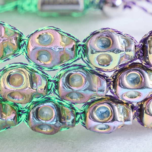 Close-up of Elysian Waves macrame bracelet showing iced silver skull beads with violet GloWeave cord by NOGU