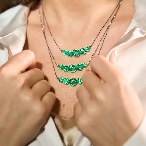 Teal Firefly Glass infinity clasp necklaces with glowing phosphorescent beads on sterling silver chains by NOGU